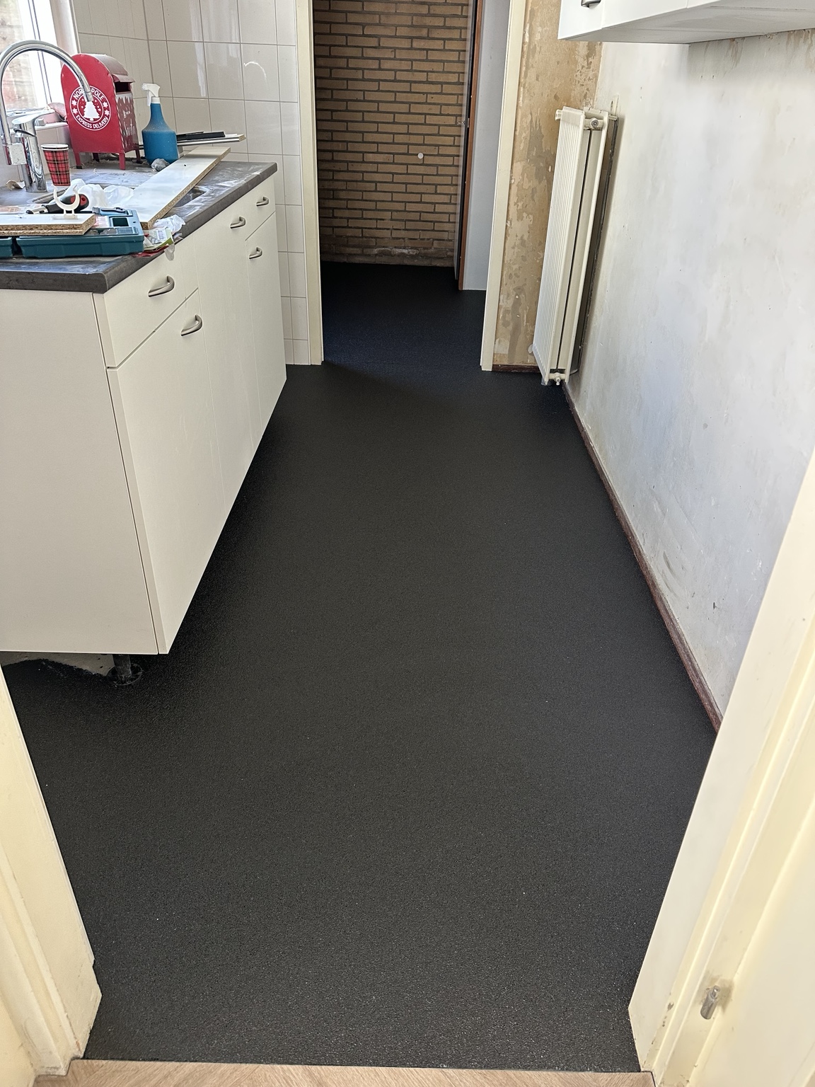 Donkere epoxy-steentapijtvloer in de keuken van een particuliere woning in Kampen