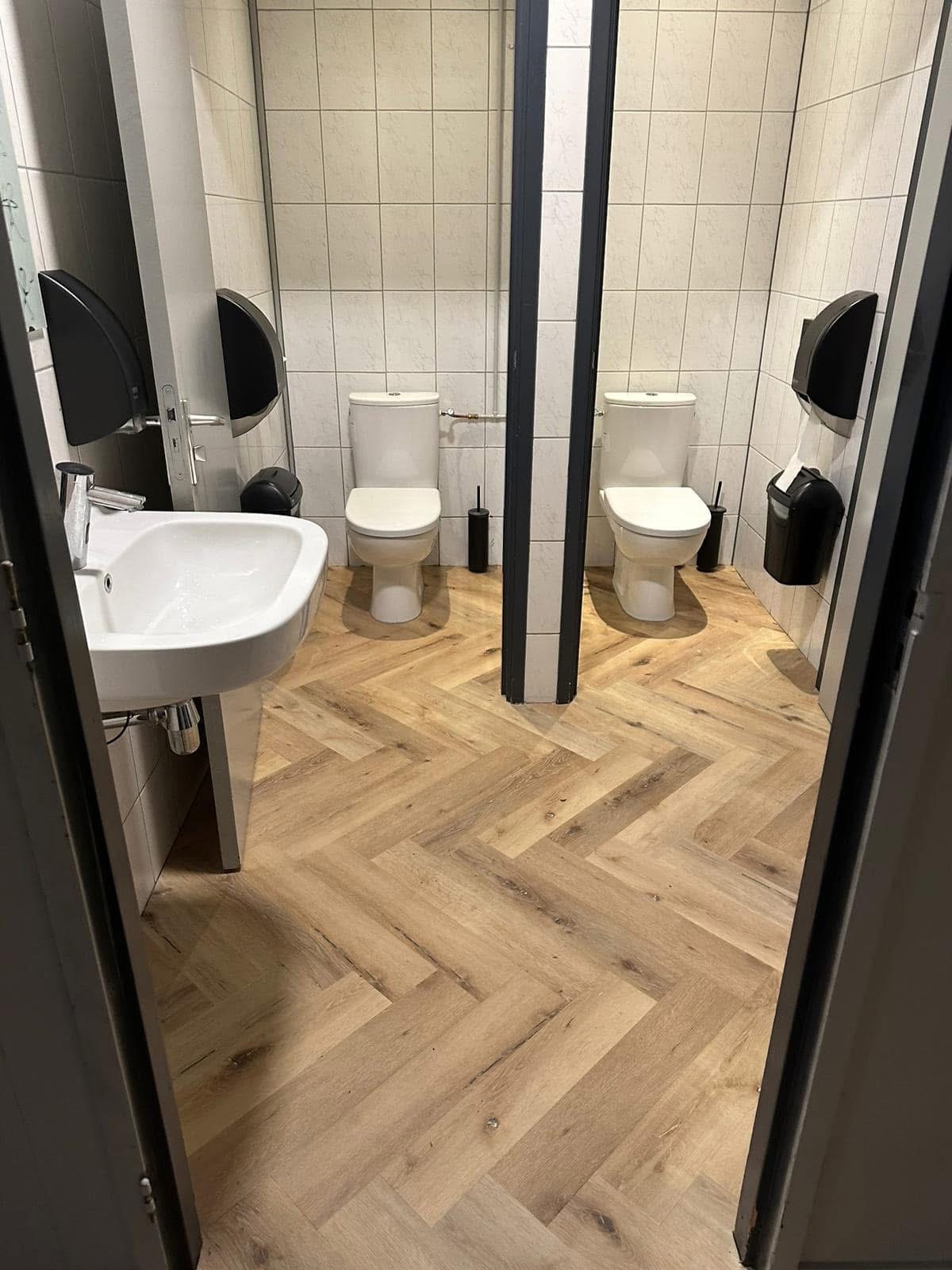 Plak-PVC in visgraatpatroon doorgelegd in de toiletruimte van het restaurant