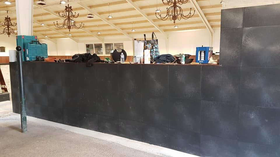 PVC-bedrijfstegels tegen een grove wand in een paardenmanege