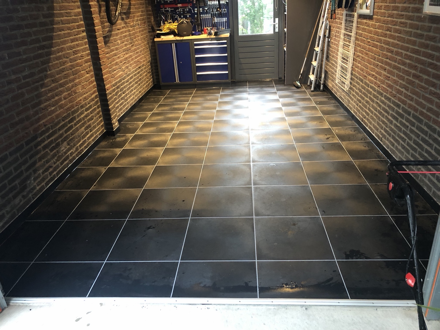 Overzicht van een particuliere garage met zwarte PVC-bedrijfsvloer
