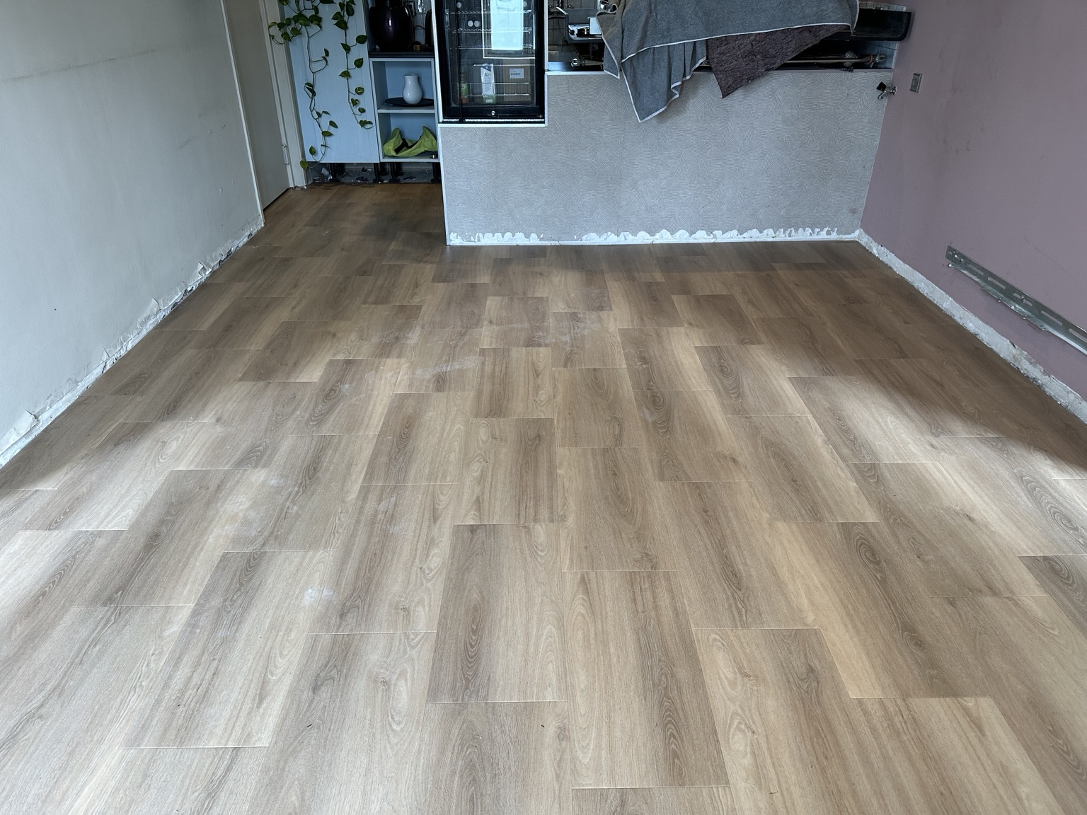 PVC-bedrijfsvloer van dikke houtlook planken met clipsysteem in de kantine van een sportschool