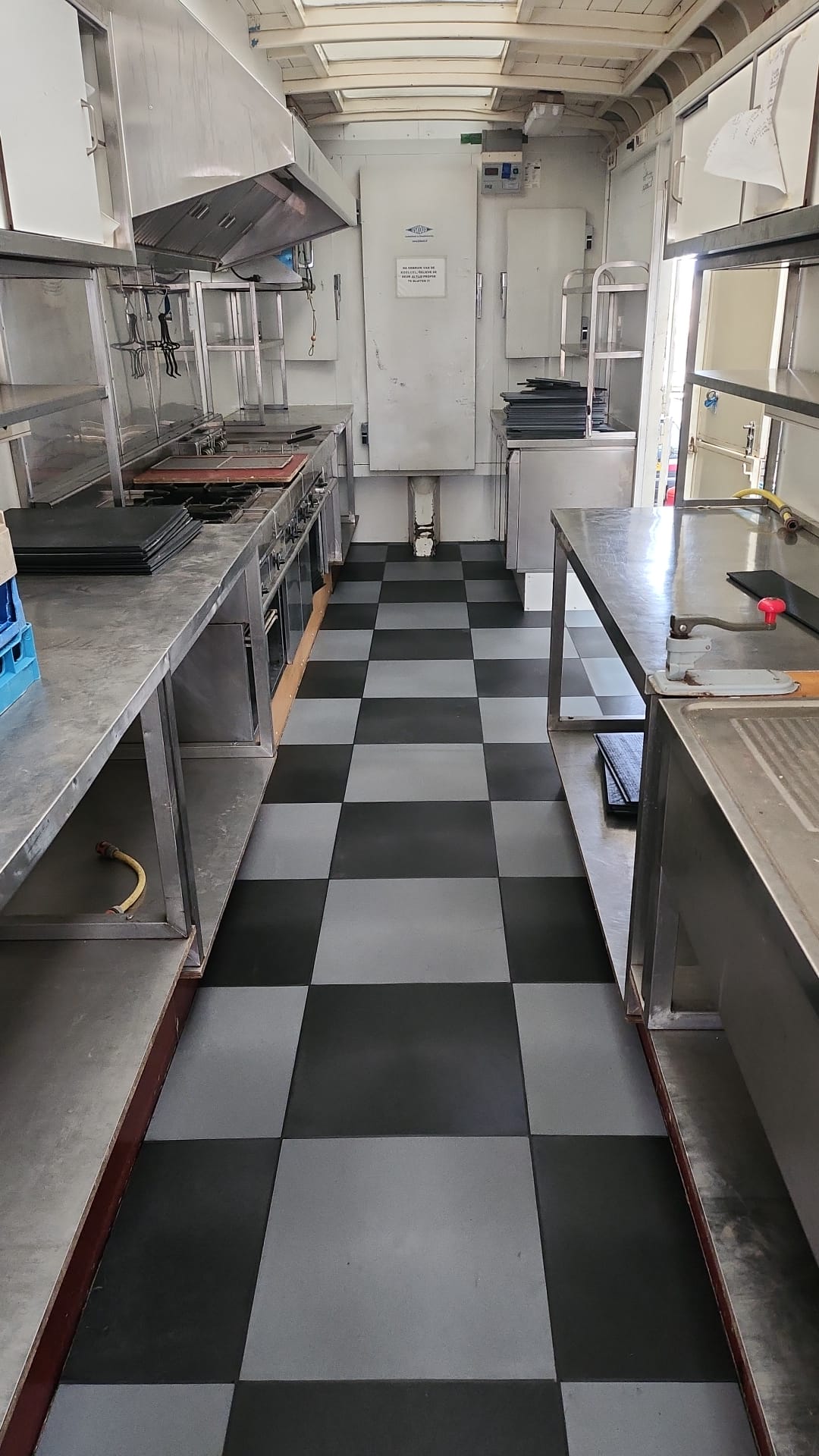 Zwart-grijze PVC-horeca-bedrijfsvloer in dambordmotief in een foodtruck